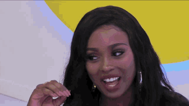 a close up of a woman 's face with a yellow and blue background