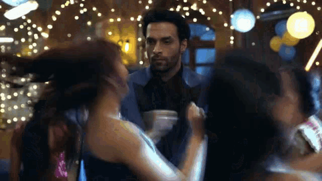 a man in a suit is dancing with a woman in a dress