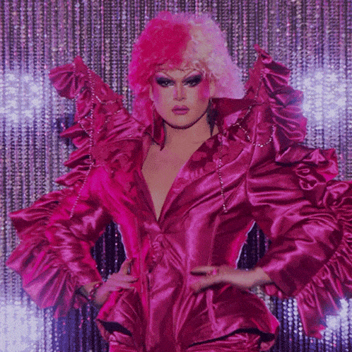a drag queen in a pink outfit with ruffles