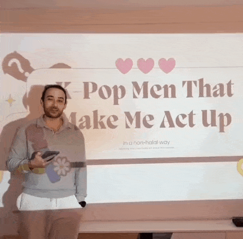 a man stands in front of a screen that says " k-pop men that make me act up "