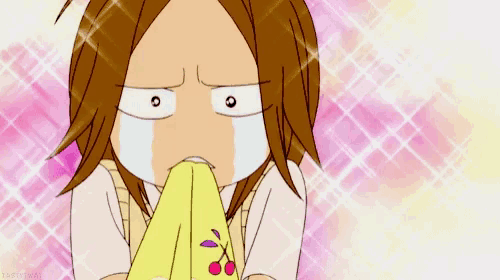 a cartoon girl is crying while holding a yellow cloth with cherries on it .