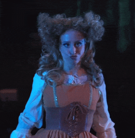 a woman wearing a corset and a wig is making a funny face