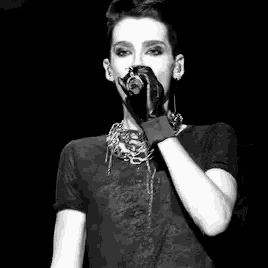 a black and white photo of a woman singing into a microphone