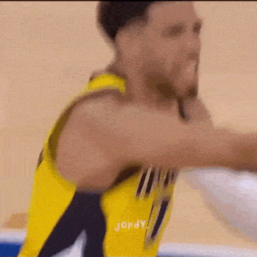 a basketball player in a yellow jersey with jordy written on the back
