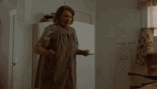 a woman in an apron is dancing in front of a fire