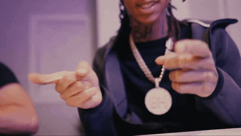 a person wearing a necklace with a pendant that says ' ss ' on it