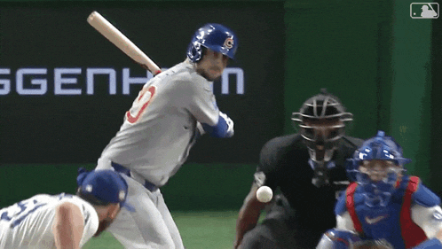 a baseball player is swinging a bat at a ball while a catcher and umpire watch