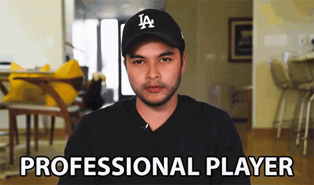 a man wearing a la hat and a black shirt says " professional player "
