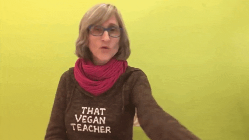 a woman wearing a sweater that says that vegan teacher