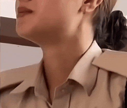 a close up of a woman 's neck with a white shirt on