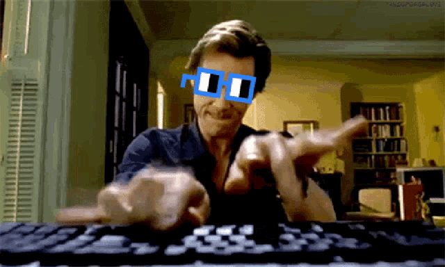 a man wearing a pair of sunglasses is typing on a keyboard