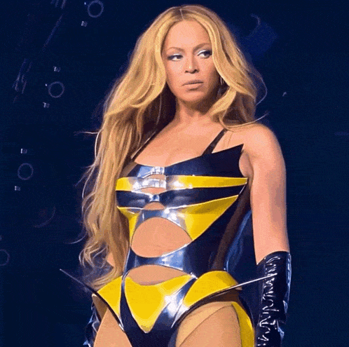 a woman with long blonde hair is wearing a yellow and black bodysuit and black gloves