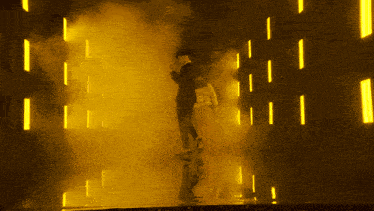 a man in a suit walks through a yellow smokey tunnel