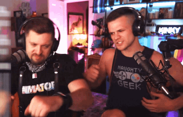 a man wearing a shirt that says naughty geek stands next to another man