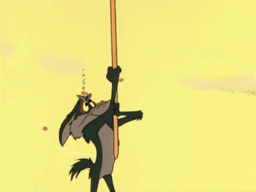 a cartoon coyote is standing on a pole .