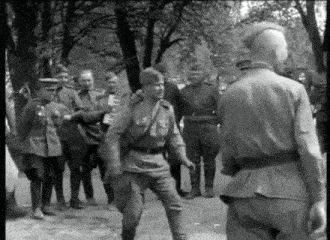 a black and white photo of a group of soldiers standing next to each other on a street .
