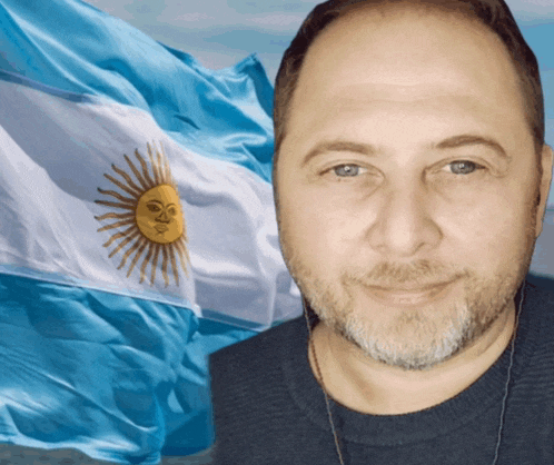 a man stands in front of a flag with the sun on it