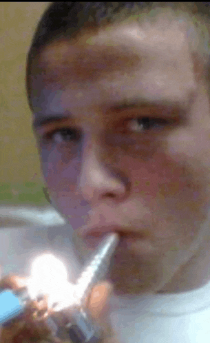 a man is smoking a cigarette with a lighter in his hand