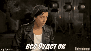 a man wearing a leather jacket and a beanie is sitting in front of a camera and says everything will be ok .