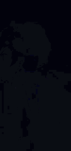 a person is holding a sword in a dark room with a purple and blue background .