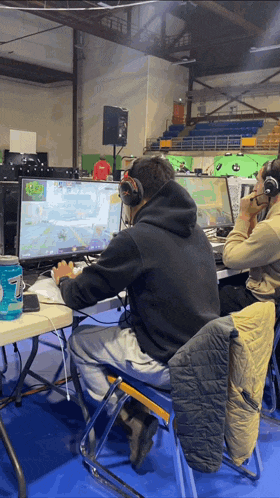 a man wearing headphones sits in front of a computer screen
