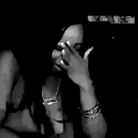 a woman wearing a necklace and earrings is holding her hand to her chest .