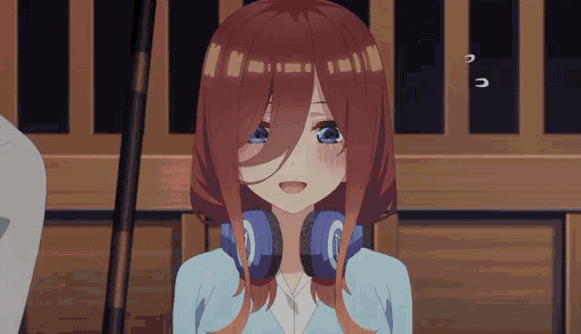 a girl with red hair and blue eyes is wearing blue headphones