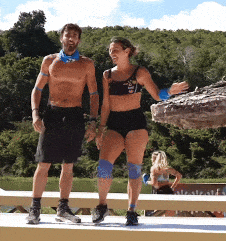 a man and a woman are standing next to each other on a wooden platform .