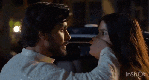 a man is touching a woman 's face with his hand .