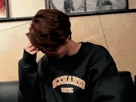 a young man wearing a black sweatshirt with the word berkeley on it .