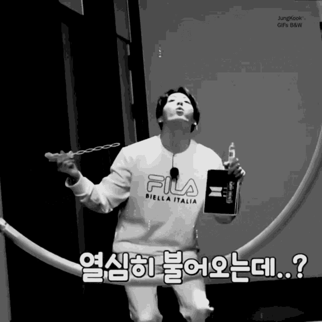 a black and white photo of a person wearing a fila sweatshirt