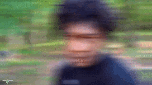a blurry picture of a man 's face with trees in the background