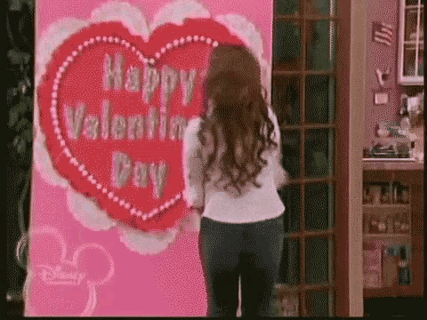 a woman is standing in front of a giant valentine 's day card .