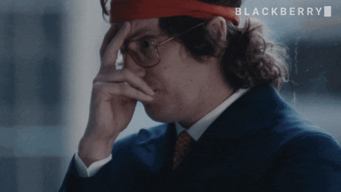 a man wearing glasses and a red headband with the word blackberry on the bottom