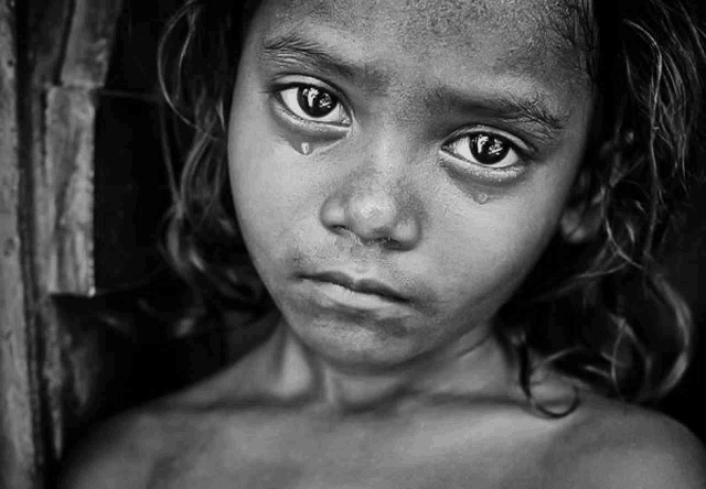 a black and white photo of a young girl with a tear coming out of her eye