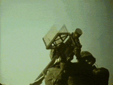 a man in a helmet is holding a device that says ' army ' on the top of it