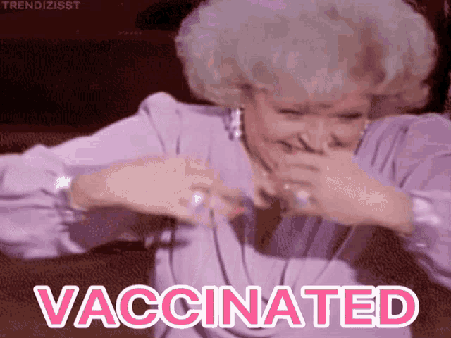 a woman in a purple dress is covering her mouth with her hand and the word vaccinated is above her
