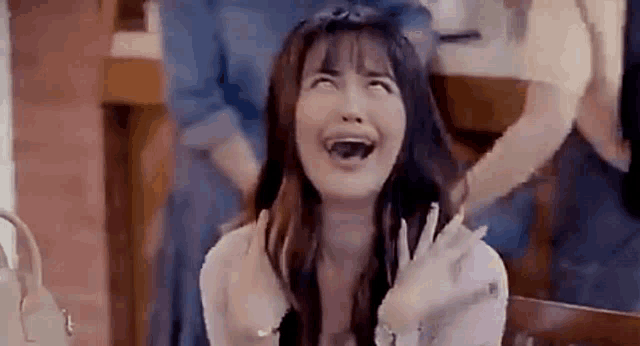 a woman is sitting in a chair making a funny face with her mouth open .