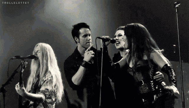 a group of people singing in front of microphones with trollslottot written on the bottom