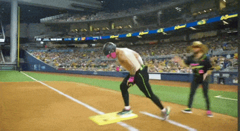 a man without a shirt is running on a yellow base