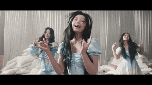 a woman in a blue dress is dancing in a room with white curtains