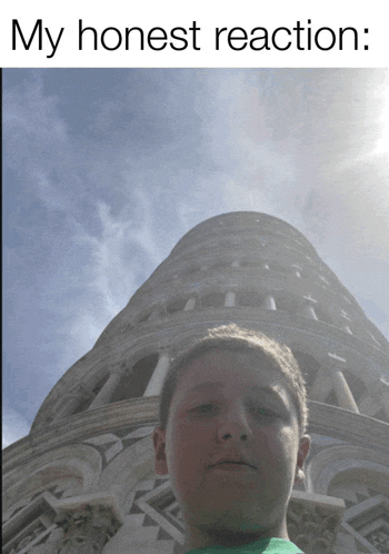 a boy is standing in front of a very tall building with the words my honest reaction below him