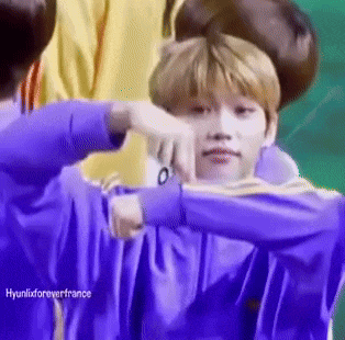 a boy in a purple shirt is being held by another boy in a yellow shirt .