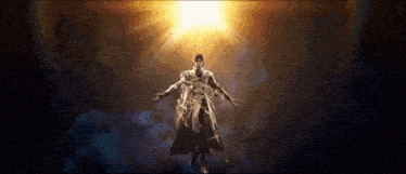 a statue of a man with his arms outstretched in front of a bright light .
