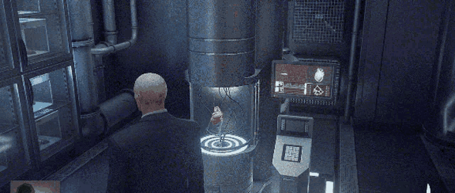a man in a suit stands in front of a machine that has the letter t on the screen