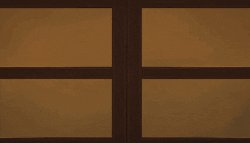 a lego character with a serious look on his face looks out a window