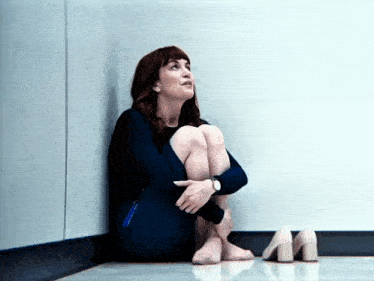 a woman sits on the floor with her legs crossed and her shoes on the floor