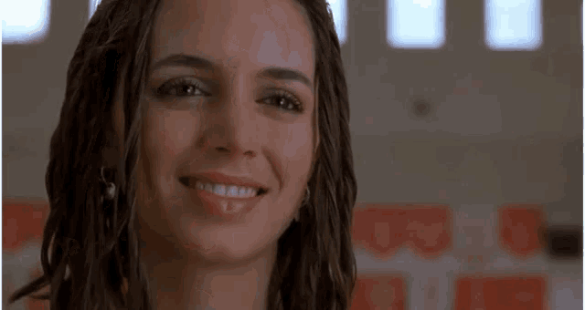 a woman is smiling and pointing at something