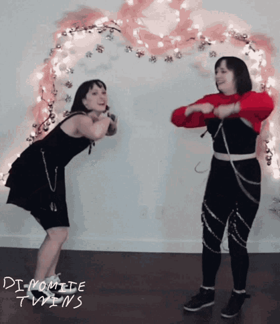 two women dancing in front of a wall that says " di momele twins "