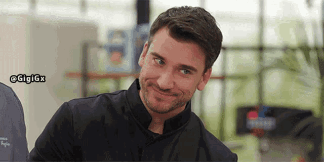 a man with a beard is smiling with the hashtag gigigx visible in the corner